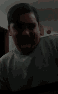 a man with a mustache is smiling for the camera .