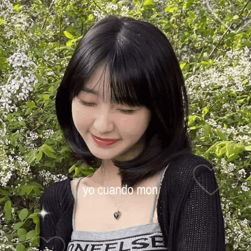 a girl wearing a black sweater and a necklace with yo cuando mon on it
