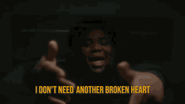 a man sitting on a bed with the words " i don t need another broken heart "