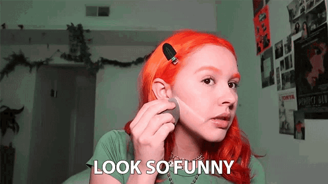 a girl with red hair is applying makeup and the words look so funny are next to her