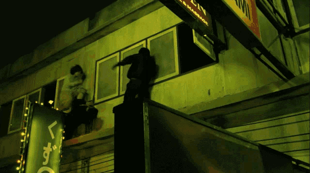 a man climbs a wall next to a sign that says ' l' amore '