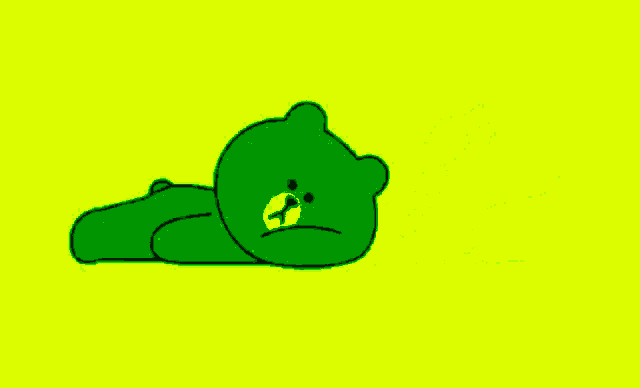 a green teddy bear is laying on a yellow background