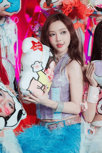 a girl in a purple top holds a stuffed animal with a picture of a girl on it