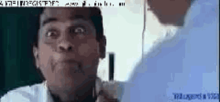 a man in a white shirt is looking at himself in a mirror