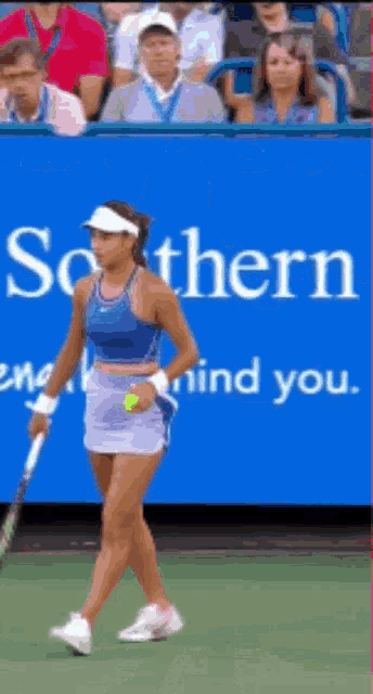a woman holding a tennis racquet on a tennis court in front of a banner that says southern