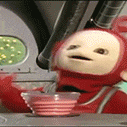 a red teletubbies toy is sitting next to a bowl of strawberry ice cream .