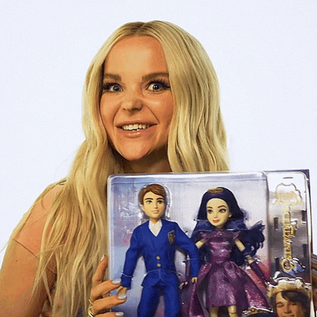 a woman is holding a box of descendants dolls in her hands