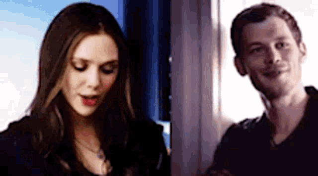 a man and a woman are standing next to each other and talking .