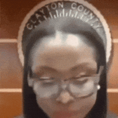 a woman wearing glasses and a clayton county headband