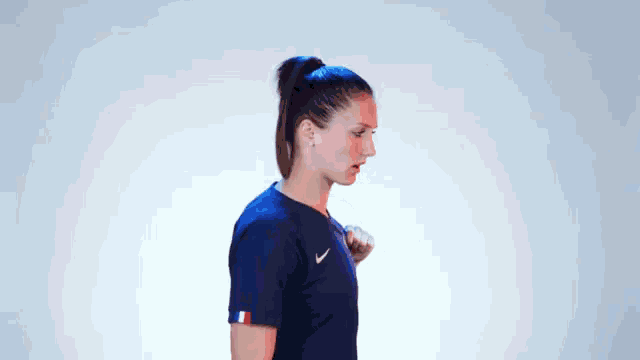 a woman wearing a blue nike shirt with a rooster on the front