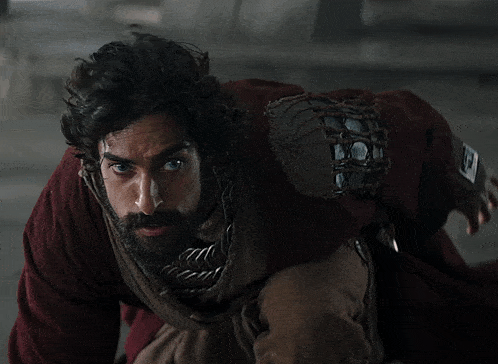 a man with a beard is wearing a red sweater