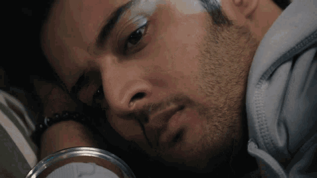 a man with a beard is laying down with his head on his arm