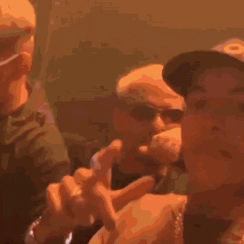 a blurry picture of two men one wearing sunglasses and a hat
