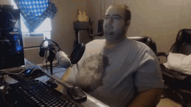 a man is sitting in front of a microphone and a keyboard