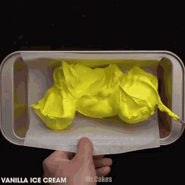 a pan of vanilla ice cream is being scooped into a loaf pan