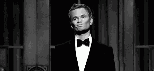 a black and white photo of a man in a tuxedo and bow tie .
