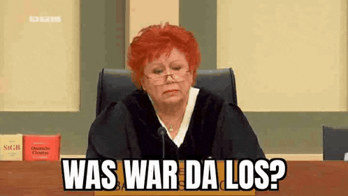 a judge with red hair is sitting at a desk in a courtroom and says `` was war da los ? ''
