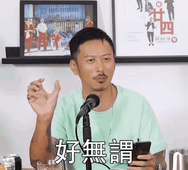 a man in a green shirt is holding a cell phone