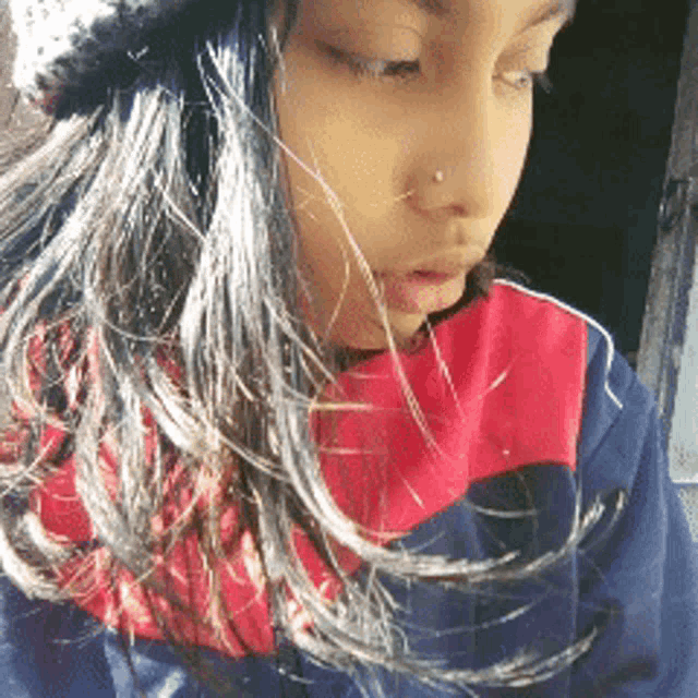 a girl with long hair wearing a red and blue shirt