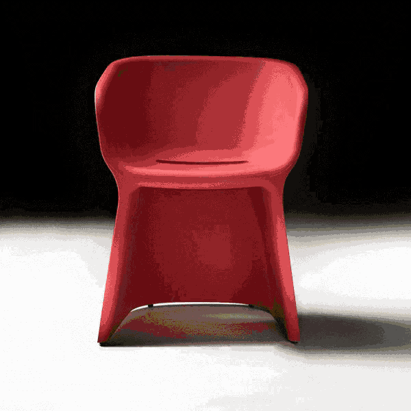 a red chair is sitting on a white surface in front of a black background