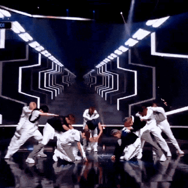 a group of dancers are performing on a stage with the number 01 in the background