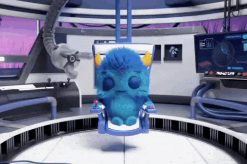 a blue stuffed animal is sitting in a chair in a room with a monitor .