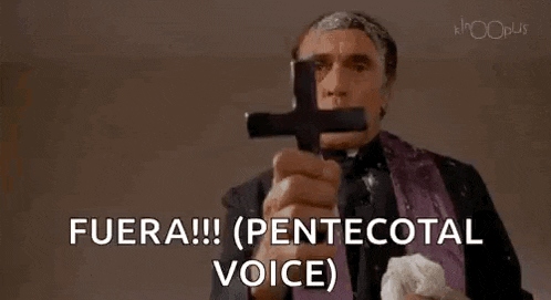a man is holding a cross in front of his face and says fuera !!! ( pentecostal voice ) .