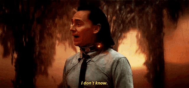 a man in a suit and tie is standing in front of a fire and saying `` i don 't know . ''