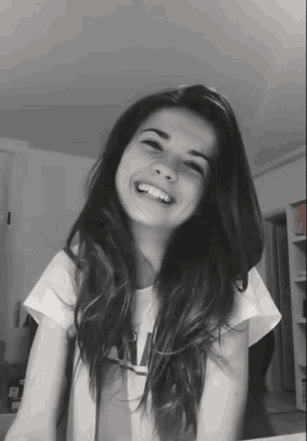 a black and white photo of a girl with long hair and a t-shirt that says ' a ' on it
