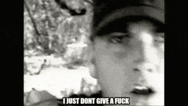 a black and white photo of a man wearing a hat and saying i just dont give a fuck