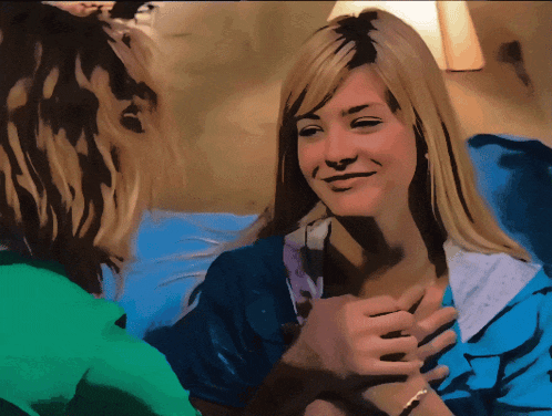 a woman in a blue shirt is smiling at another woman