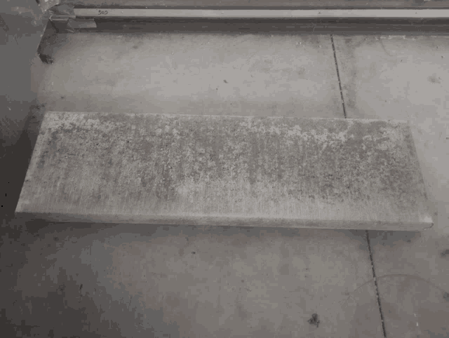 a piece of concrete sits on a concrete floor next to a door