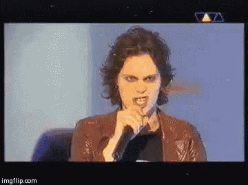 a woman singing into a microphone on a tv screen with imgflip.com at the bottom