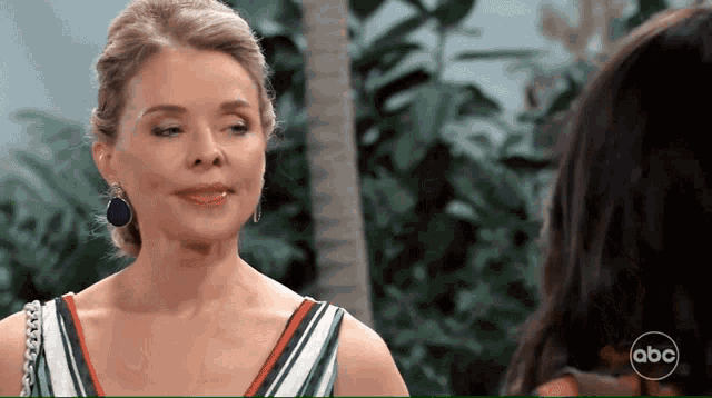 a woman in a striped dress is talking to another woman with a abc logo in the corner