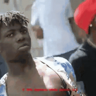 a man with dreadlocks is wearing a blue and white shirt