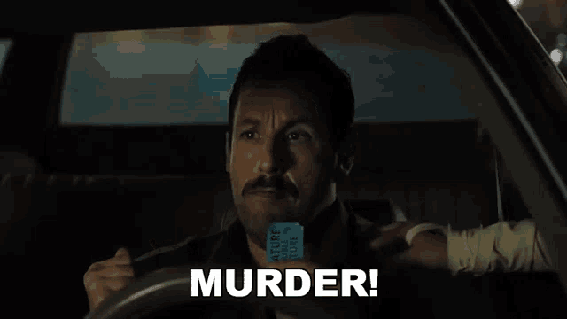 a man is driving a car and holding a cell phone .