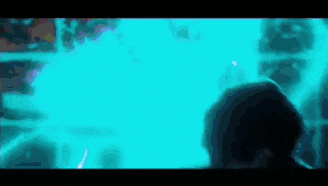 a person is standing in front of a large aquarium filled with fish .