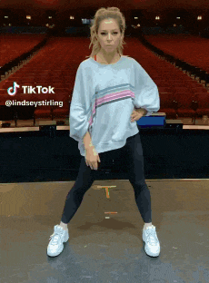 a woman is standing on a stage in front of a large auditorium ..