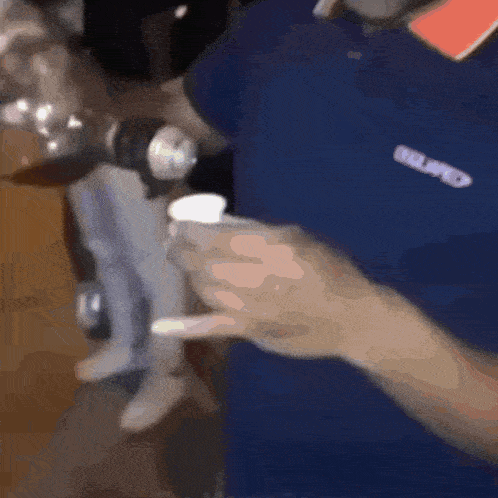 a man wearing a blue shirt that says belimed