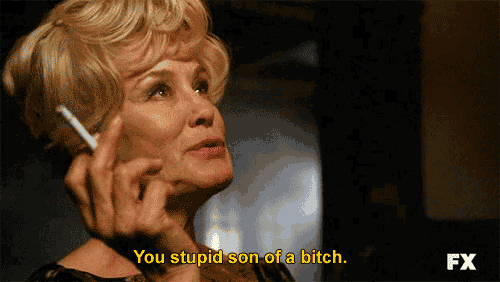 a woman is smoking a cigarette and saying you stupid son of a bitch