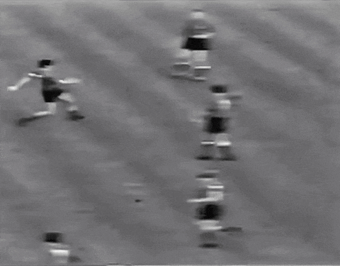 a black and white photo of a soccer goal with a person in the background .