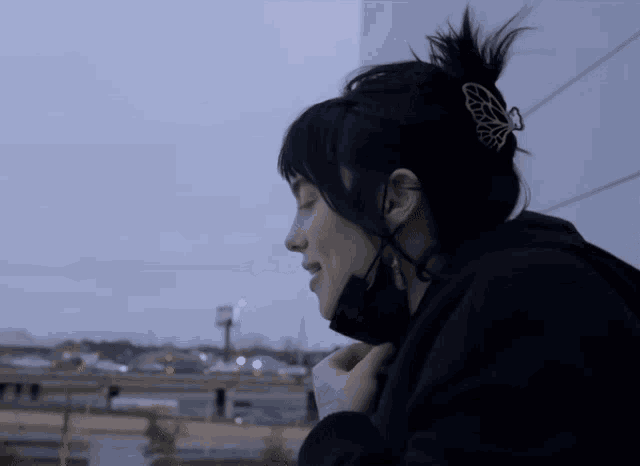 a woman wearing a black hoodie and a black mask