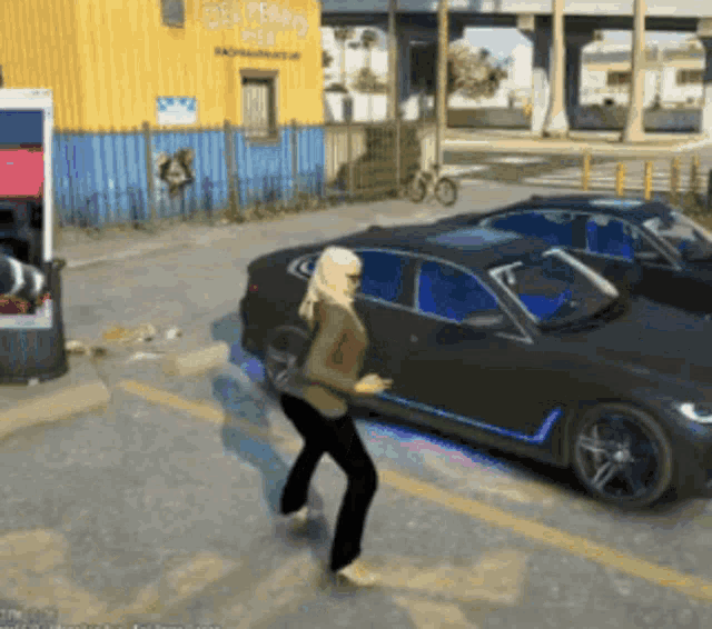 a woman is walking towards a black car in front of a building that says dealership