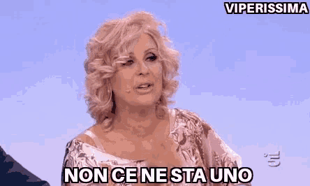 a woman is sitting on a stage with the words non ce ne sta uno in front of her