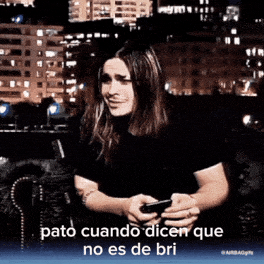 a man with long hair is holding a cell phone and says pato cuando dicen que no es de bri in spanish