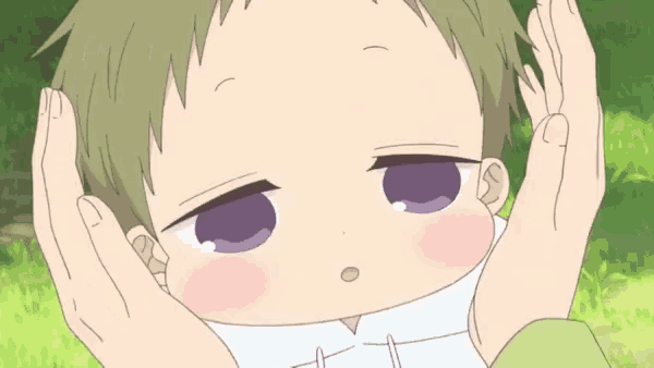 a close up of a baby with his hands on his face .