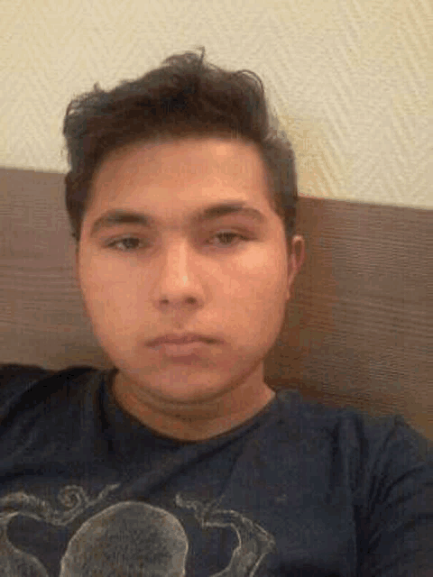 a young man is taking a selfie while laying on a bed .