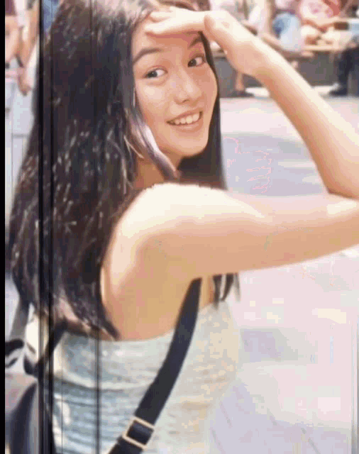 a young woman covering her face with her hand and smiling