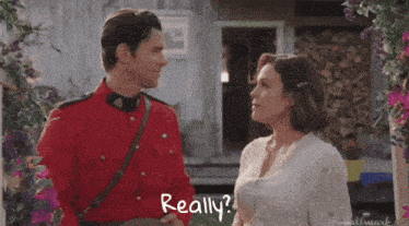 a man in a red uniform and a woman in a white shirt are standing next to each other and the words really are visible