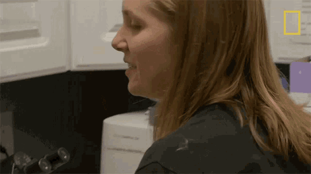 a woman in a kitchen with a national geographic logo on her shoulder